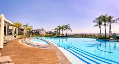 a swimming pool at a resort with palm trees at AlimamaSpaces Semandi Polofields in Midrand