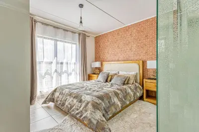 a bedroom with a bed and a large window at AlimamaSpaces Semandi Polofields in Midrand
