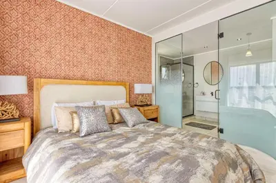 a bedroom with a large bed and a glass shower at AlimamaSpaces Semandi Polofields in Midrand