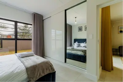 a bedroom with a bed and a large glass window at AlimamaSpaces Josephs Polofields in Midrand