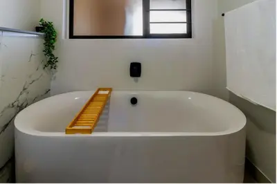 a white bath tub with a ladder in a bathroom at AlimamaSpaces Josephs Polofields in Midrand