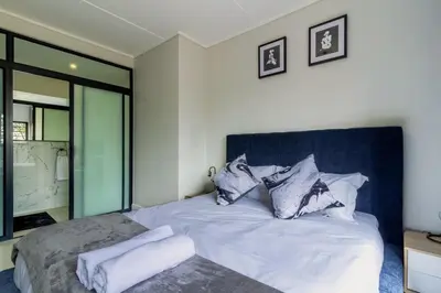 a bedroom with a bed with white sheets and pillows at AlimamaSpaces Josephs Polofields in Midrand