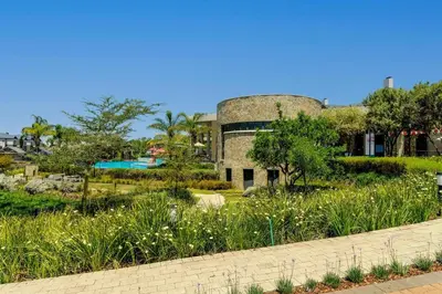 a building with a pool in the middle of a garden at AlimamaSpaces Josephs Polofields in Midrand