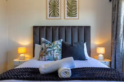 a bedroom with a large bed with two lamps at AlimamaSpaces Panos Whisken in Midrand