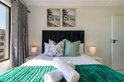 a bedroom with a bed with a green blanket at AlimamaSpaces Panos Whisken in Midrand