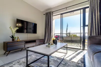 a living room with a couch and a table at AlimamaSpaces Panos Whisken in Midrand