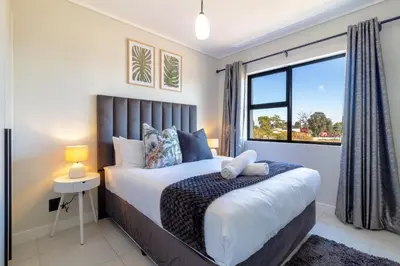 a bedroom with a large bed and a window at AlimamaSpaces Panos Whisken in Midrand