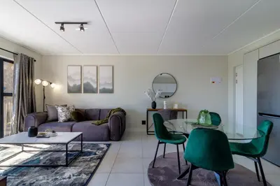 a living room with a couch and a table at AlimamaSpaces Panos Whisken in Midrand