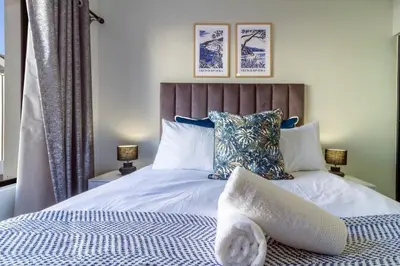 a bedroom with a bed with a blue and white comforter at AlimamaSpaces Phillys Whisken in Midrand