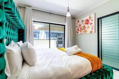 a bedroom with a large bed with a large window at AlimamaSpaces Farais Whisken Apartment in Midrand