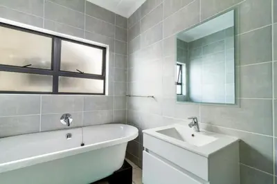 a bathroom with a tub and a sink and a bath tub at AlimamaSpaces Farais Whisken Apartment in Midrand
