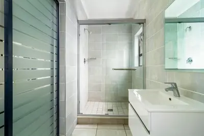 a bathroom with a shower and a sink at AlimamaSpaces Farais Whisken Apartment in Midrand