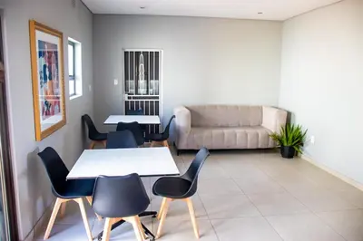 a living room with tables and chairs and a couch at Glowti Event & Guest House in Centurion