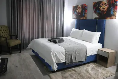 a bedroom with a bed with a blue headboard at Glowti Event & Guest House in Centurion