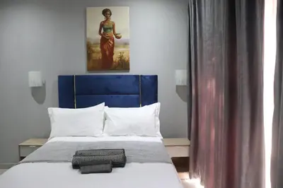 a bed with a blue headboard in a room at Glowti Event & Guest House in Centurion