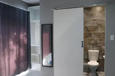 a bathroom with a toilet and a shower at Glowti Event & Guest House in Centurion
