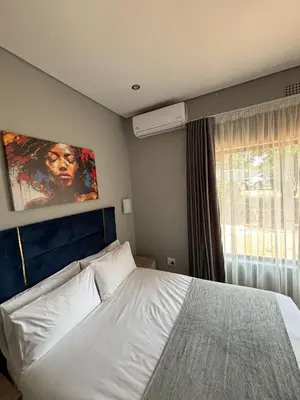 a bedroom with a white bed and a window at Glowti Event & Guest House in Centurion