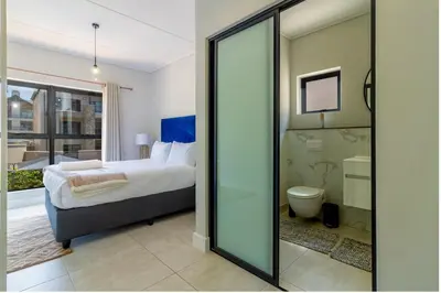 a bedroom with a bed and a bathroom at #AlimamaSpaces Jay's Polofields in Midrand