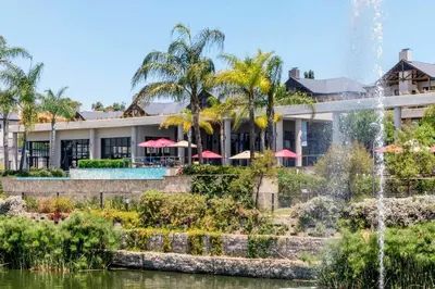 a hotel with a fountain in front of a building at #AlimamaSpaces Jay's Polofields in Midrand