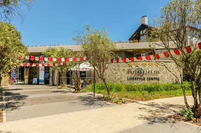 a building with red and white flags in front of it at #AlimamaSpaces Jay's Polofields in Midrand
