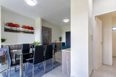 a dining room with a table and chairs at #AlimamaSpaces The Manson's Kyalami Woods in Midrand