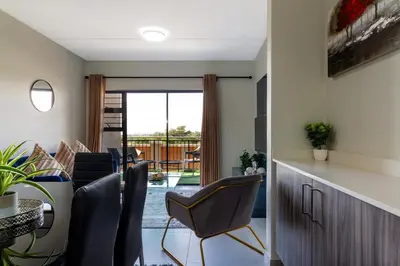 a living room with chairs and a view of a patio at #AlimamaSpaces The Manson's Kyalami Woods in Midrand