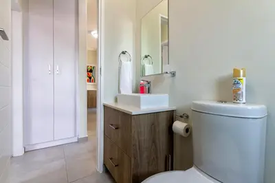 a bathroom with a white toilet and a sink at #AlimamaSpaces The Rob's Kyalami Woods in Midrand