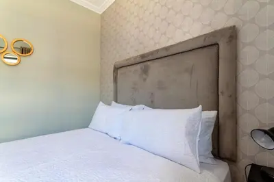 a bed with a large headboard in a bedroom at #AlimamaSpaces The Rob's Kyalami Woods in Midrand