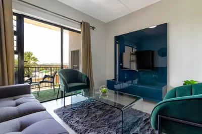 a living room with a couch and a glass table at #AlimamaSpaces The Chelsea Kyalami Woods in Midrand