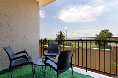 a balcony with chairs and a table with a view at #AlimamaSpaces The Chelsea Kyalami Woods in Midrand
