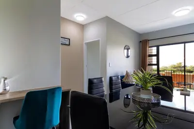 a waiting room with chairs and a table and a balcony at #AlimamaSpaces The Bob's Kyalami Woods in Midrand