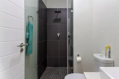 a bathroom with a shower with a toilet and a sink at #AlimamaSpaces The Bob's Kyalami Woods in Midrand