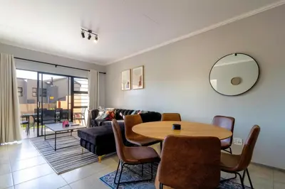 a living room with a table and a couch at #AlimamaSpaces Thando's Waterfalls Villa in Midrand