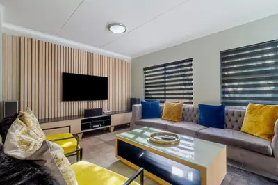 a living room with a couch and a tv at #AlimamaSpaces The Manson Umthunzi View in Vosburg