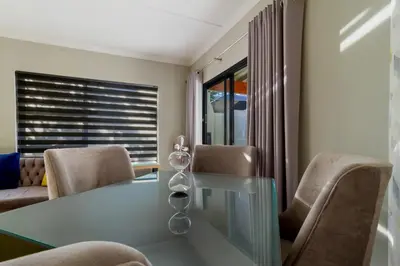 a dining room with a glass table and chairs at #AlimamaSpaces The Manson Umthunzi View in Vosburg