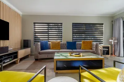 a living room with a couch and a tv at #AlimamaSpaces The Manson Umthunzi View in Vosburg