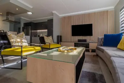 a living room with a couch and a tv at #AlimamaSpaces The Manson Umthunzi View in Vosburg