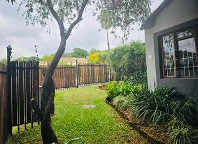a yard with a fence and a tree at The Chardonnay Inn in Centurion