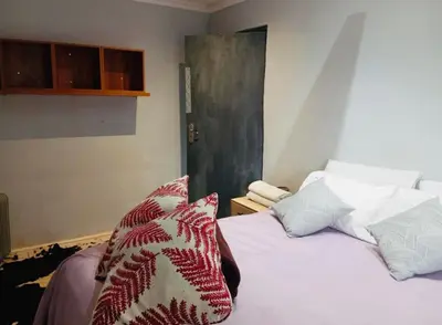 a bedroom with a bed with pillows on it at The Chardonnay Inn in Centurion