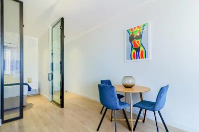 a dining room with a table and blue chairs at #AlimamaSpaces The Chelsea's Cassini Ellipse in Vosburg