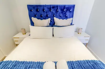 a bedroom with a bed with a blue headboard at #AlimamaSpaces The Chelsea's Cassini Ellipse in Vosburg