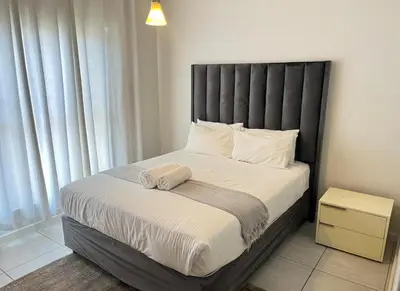 a bed with a black headboard in a bedroom at Upmarket Luxury 1 bedroom Apartment in Kyalami