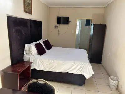 a bedroom with a large bed and a shower at C'est Si Bon Accommodation at 53 Van Heerden Mokopane in Mokopane
