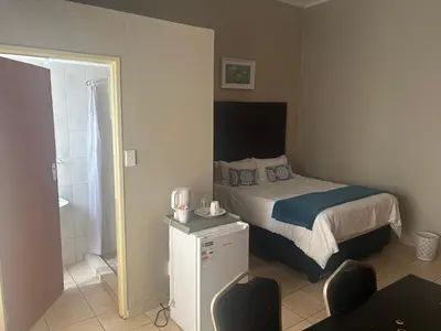 a small bedroom with a bed and a bathroom at C'est Si Bon Accommodation at 53 Van Heerden Mokopane in Mokopane