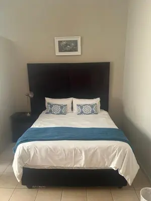 a bedroom with a large bed with a black headboard at C'est Si Bon Accommodation at 53 Van Heerden Mokopane in Mokopane