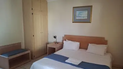 a small bedroom with a bed and a chair at C'est Si Bon Accommodation at 03 Beitel, Mokopane in Mokopane