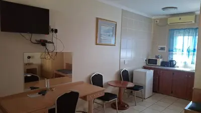 a room with a table and chairs and a kitchen at C'est Si Bon Accommodation at 03 Beitel, Mokopane in Mokopane