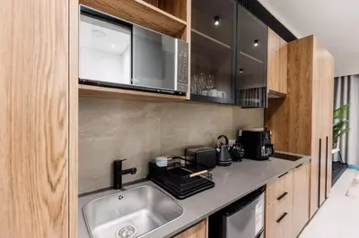 a kitchen with a sink and a microwave at Modern & Peaceful Studio in Pretoria