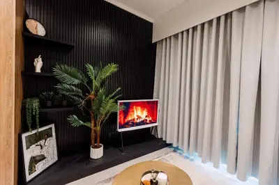 a living room with a tv with a fire in it at Modern & Peaceful Studio in Pretoria