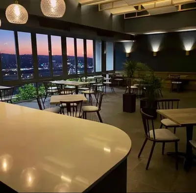 a restaurant with tables and chairs and a view at Modern & Peaceful Studio in Pretoria